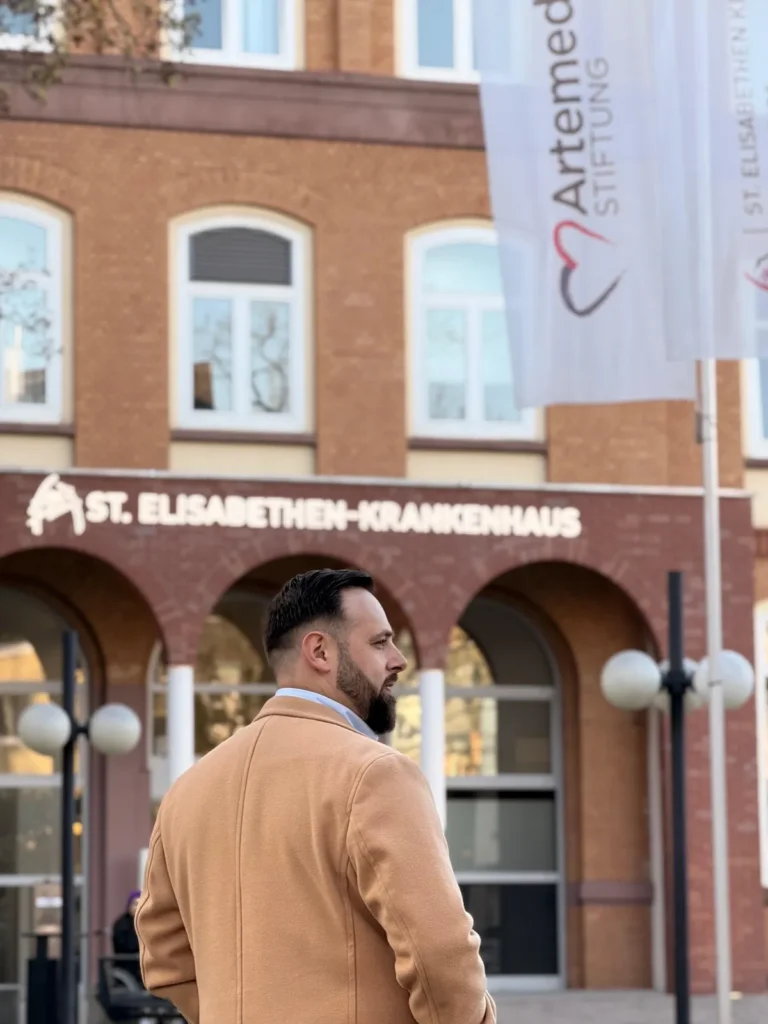 Dr. Amel Havkic vor dem St. Elisabethen-Krankenhaus in Frankfurt – langjährige klinische Erfahrung in Intensivmedizin, Weaning und Heimbeatmung fließt direkt in seine pneumologische Privatpraxis ein